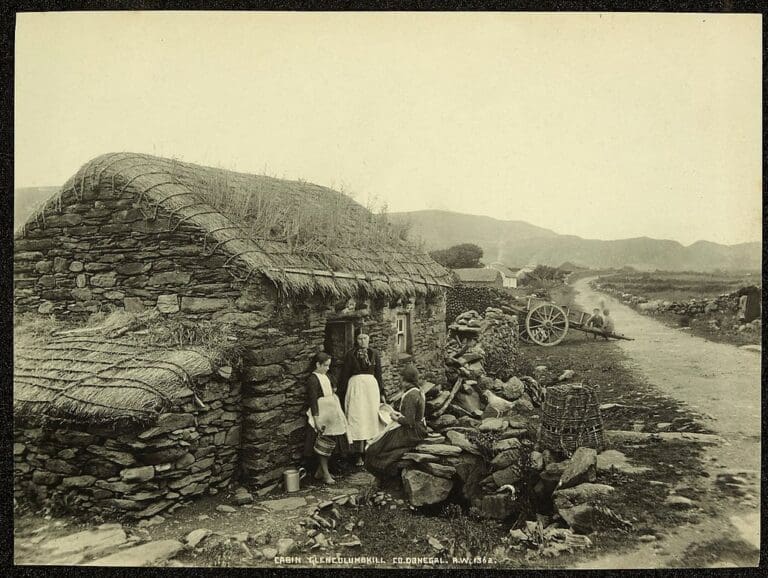 A photo of three people in front of a cottage in Glencolumbkill in Northern Ireland.